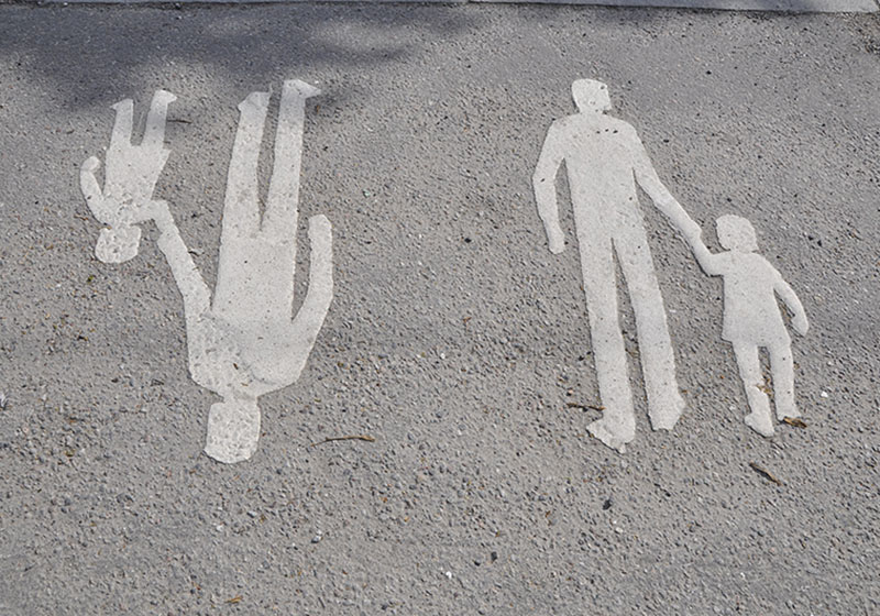 Vita herrgårman-markeringar på asfalt